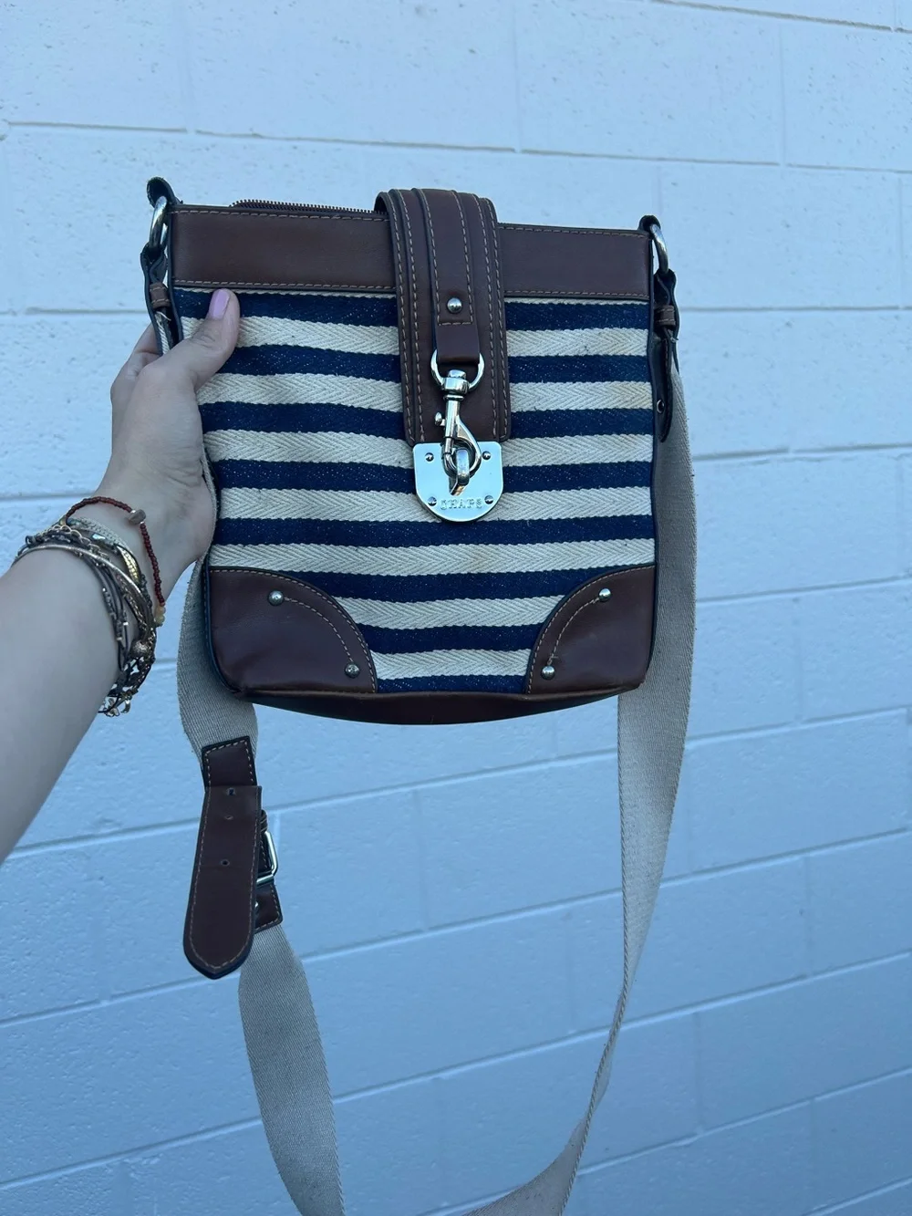 Chaps nautical crossbody bag featuring a navy and white striped canvas body